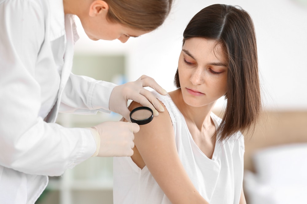 A patient having her arm looked at closely by her dermatologist to evaluate possible cherry angiomas.